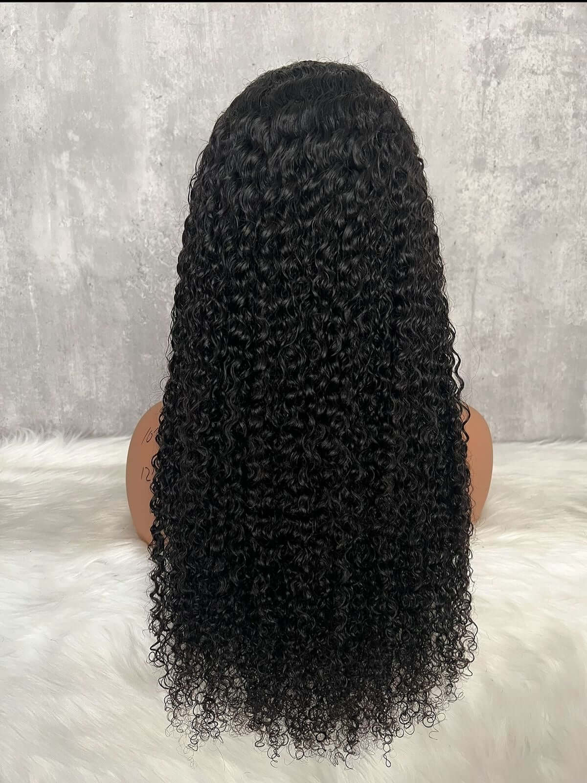 Mujer luciendo peluca rizada de cabello natural con acabado profesional y volumen definido, modelo Barrio de Salamanca.